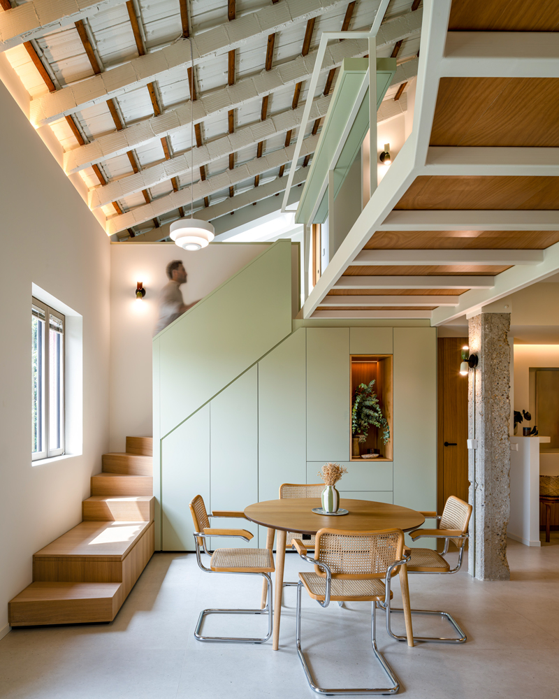 Fotografía de arquitectura residencial en Murcia, comedor y escalera en Casa Melón Fotografía de arquitectura residencial en Murcia que muestra el comedor y la escalera de madera con barandilla blanca integrados en Casa Melón.