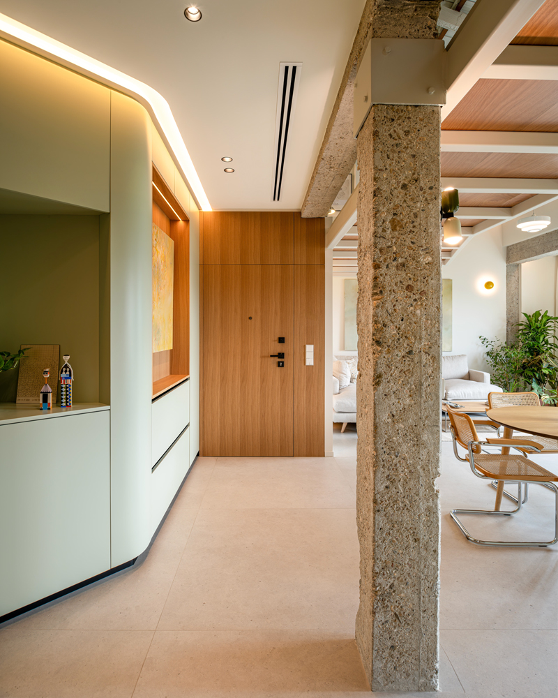 Arquitectura e interiorismo, entrada con estructura vista en Casa Melón Fotografía de arquitectura e interiorismo que muestra el acceso principal de Casa Melón, con pilar de hormigón visto y carpintería de madera natural.