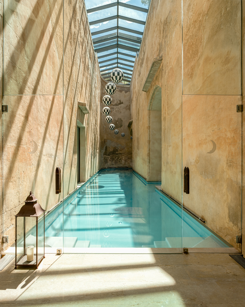 Piscina interior alargada del spa de Cap Rocat bajo una cubierta acristalada