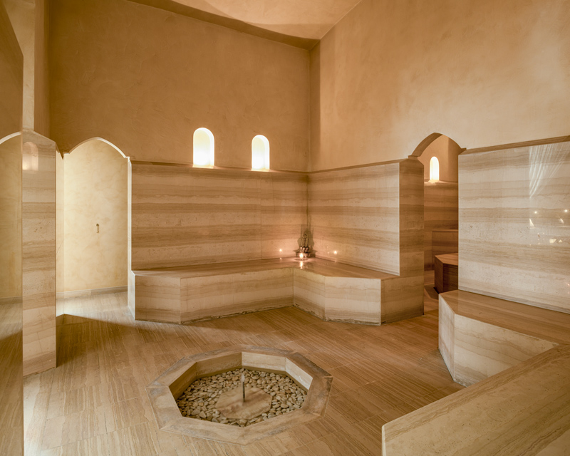 Interior del hammam de Cap Rocat con bancos de piedra y una fuente central